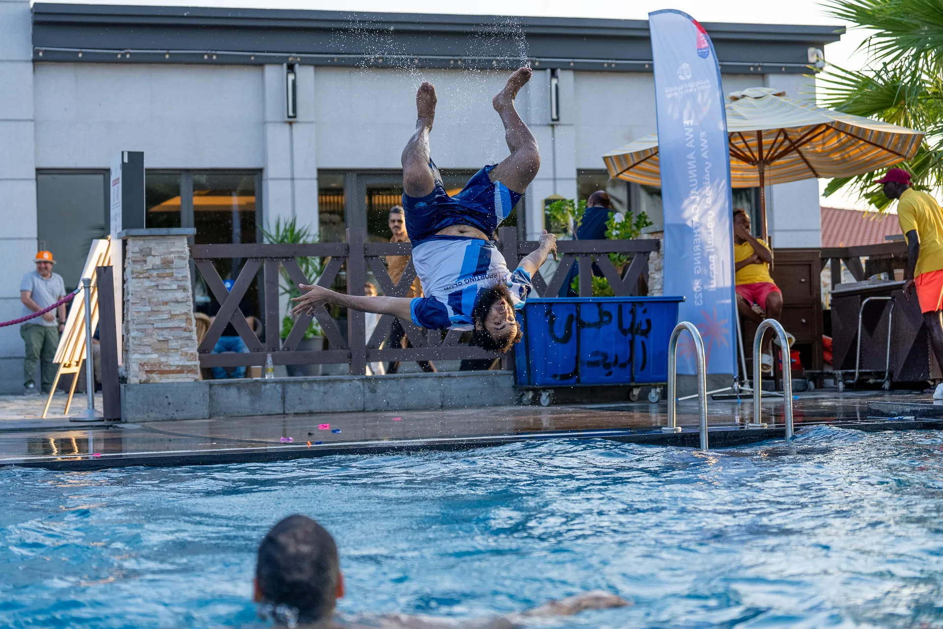 Backflip frozen mid-air over a hotel pool