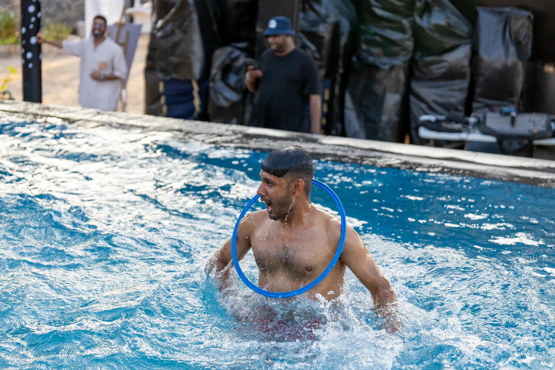 Swimmer in the pool mid-game with a blue hoop around his shoulders