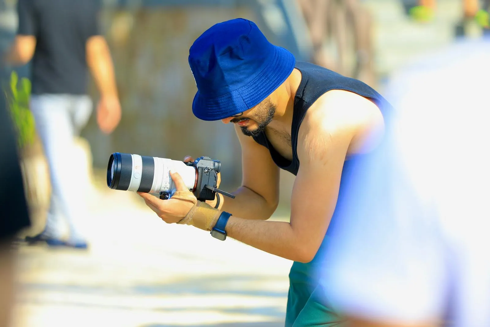 The photographer crouched low, shooting with a white telephoto lens
